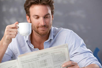 Mann mit Kaffee liest die SVZ